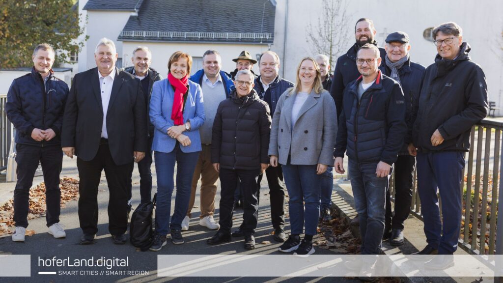 Delegation besucht Pilotprojekt Hochwasserschutz in Issigau, IoT-Sensoren messen Wasserstände für Frühwarnsysteme.